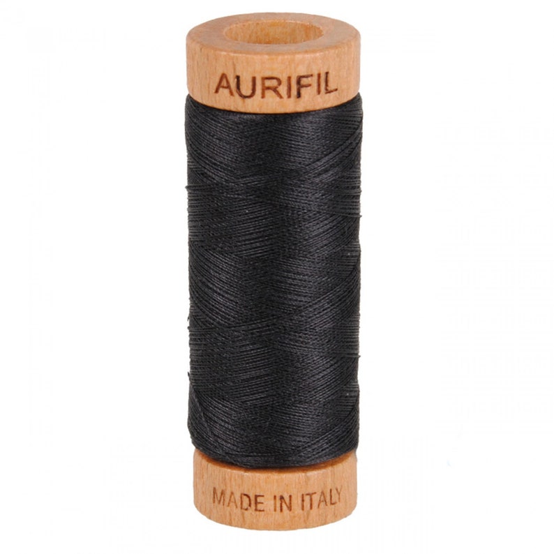 May include: A spool of black thread with a wooden bobbin. The bobbin is labeled "Aurifil" and "Made in Italy".