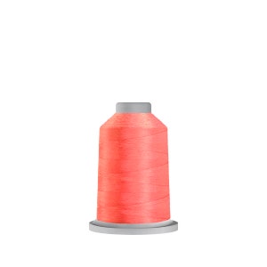 Puede incluir: Una bobina de hilo de color coral brillante con una bobina de plástico blanca.