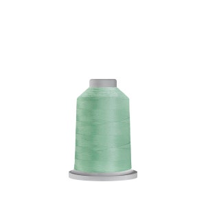 May include: A spool of light green thread on a white bobbin.