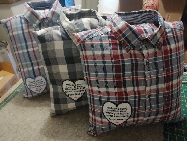 Puede incluir: Tres camisas de cuadros cosidas en fundas de almohada con parches en forma de coraz&oacute;n que dicen "This is a shirt I used to wear When you hold it Know I am there Love Dad".