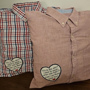 Puede incluir: Dos fundas de almohada de cuadros rojos y blancos con corazones bordados y mensajes. Los mensajes dicen "This is the shirt I used to wear. When you hold it know I am there Love Roy" y "This is the shirt I used to wear. When you hold it know I am there Love Dad".