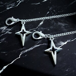 May include: Two silver chains with star-shaped charms. Each chain has a lobster clasp.