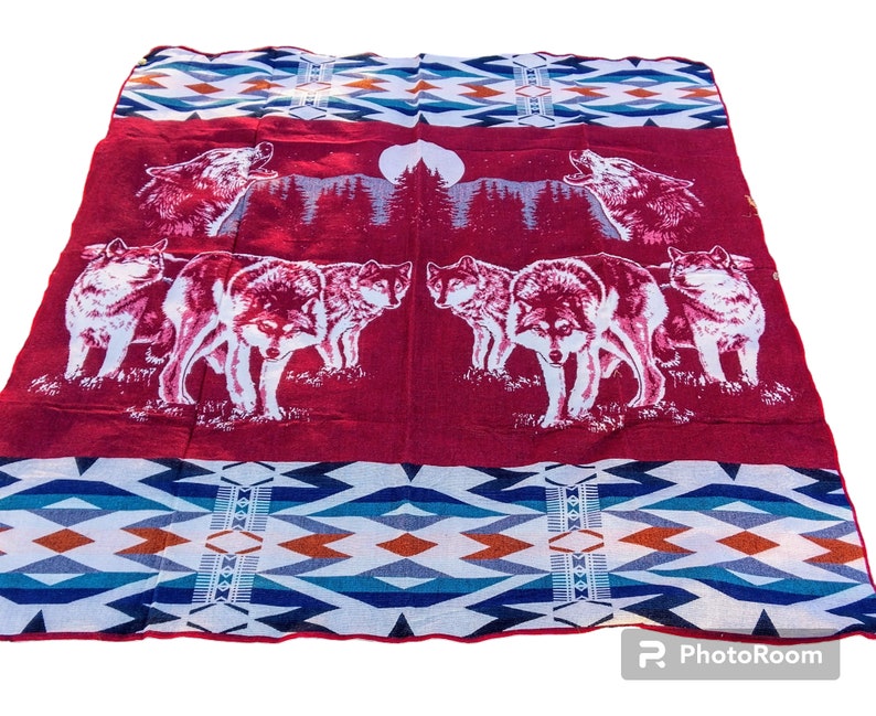May include: Red and blue patterned throw blanket with a design of wolves howling at the moon.
