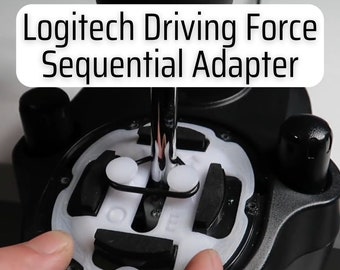 May include: Close-up of a Logitech Driving Force Sequential Adapter with a white plastic adapter attached to the shifter. The adapter is designed to allow the use of a sequential shifter with the Logitech Driving Force steering wheel.