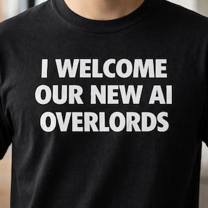 以下が含まれることがあります： 白い文字で「I WELCOME OUR NEW AI OVERLORDS」と書かれた黒いTシャツ。テキストは太字のサンセリフ体です。Tシャツはクルーネックです。