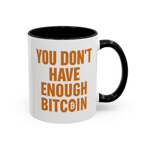May include: White ceramic mug with a black interior and handle. The mug displays the orange text "YOU DON'T HAVE ENOUGH BITCOIN" and a Bitcoin symbol. A humorous gift for cryptocurrency fans.