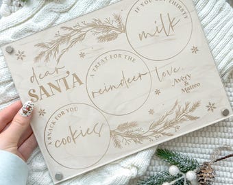 May include: A wooden Christmas Eve tray with four circular sections. The sections are labeled "dear SANTA", "A TREAT FOR THE reindeer", "IF YOU GET THIRSTY milk", and "A SNACK FOR YOU cookies". The tray is decorated with a gold-colored floral design.
