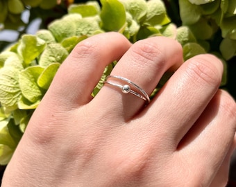 Handgjord silverring mot ångest gjord av två sammanfogade tunna ringar och en rund silverpärla