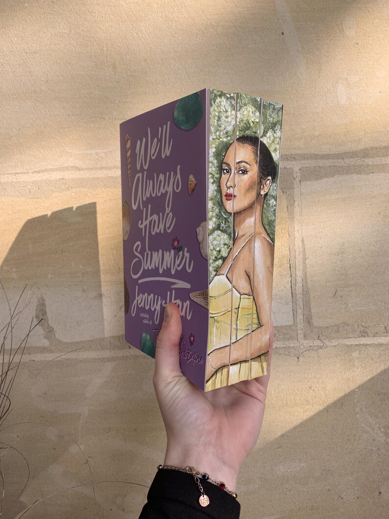 Pode incluir: Um livro de capa dura intitulado "We'll Always Have Summer" de Jenny Han. O livro tem uma capa roxa com ilustra&ccedil;&otilde;es e texto. A lateral do livro apresenta um retrato pintado de uma mulher em um vestido amarelo.