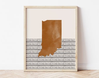 May include: A framed print of the state of Indiana in a brown silhouette on a white background with a black and white geometric pattern at the bottom.