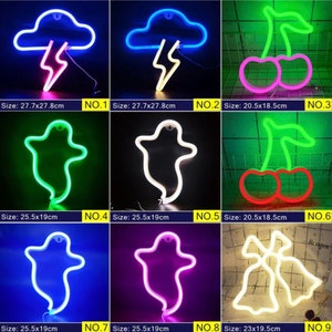 May include: A collection of neon light signs in various shapes, including a cloud with lightning, cherries, a ghost, and bells. The signs are in different colors, with sizes ranging from 20.5x18.5cm to 27.7x27.8cm.
