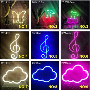 May include: A collection of neon signs in various shapes, including a butterfly, cherries, a treble clef, and clouds. Each sign has a different color, and the dimensions are provided in inches and centimeters.