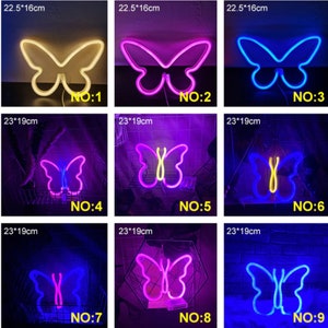 May include: A collection of neon butterfly signs in various colors, including white, pink, and blue. Each sign is a different size, with the largest measuring 23cm x 19cm. The signs are numbered 1 through 9.