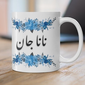 May include: White ceramic mug with a blue floral design and the text "Nana Jan" in black.