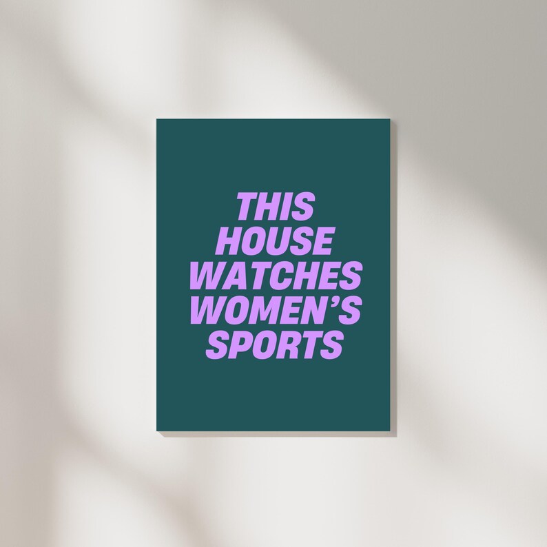 Pode incluir: Um cartaz verde-azulado com o texto "THIS HOUSE WATCHES WOMEN'S SPORTS" em roxo.