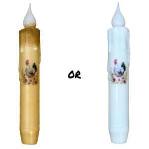 May include: Two battery-operated LED candles with a chicken and floral design. The candle on the left is a yellow color and the candle on the right is white.