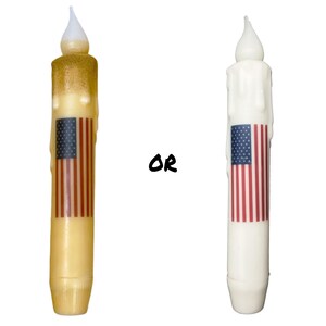 May include: Two candles with a dripping wax design. Both candles have an American flag design on the side. The candle on the left is a light yellow color. The candle on the right is white. The text "OR" is printed in black between the candles.
