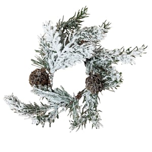 May include: A circular Christmas decoration featuring green pine needles dusted with white snow and two brown pine cones. The festive wreath is set against a white background, perfect for holiday decor.