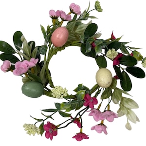 May include: A decorative Easter wreath featuring pink and green speckled eggs, pink flowers, and green leaves. The wreath is circular and has a natural, springtime aesthetic. The wreath is perfect for Easter decorations.