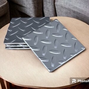 May include: Set of four silver metal coasters with a diamond plate pattern.