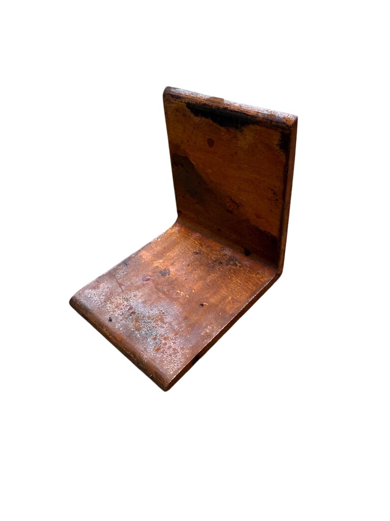 May include: A copper-colored, L-shaped metal bracket. The bracket has a weathered appearance with dark brown and light brown tones. The metal appears to have a slightly textured surface, with some areas showing signs of oxidation.