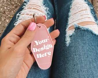 May include: Pink motel key chain with the text "Your Design Here" in white lettering.
