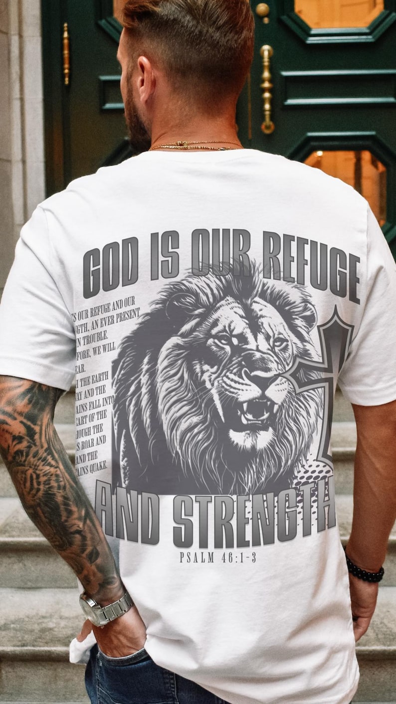 May include: White t-shirt with a large graphic of a roaring lion and the text "GOD IS OUR REFUGE AND STRENGTH" in gray. The shirt also features the Bible verse Psalm 46:1-3.