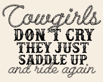 Può includere: Grafica color crema con la scritta "Cowgirls Don't Cry They Just Saddle Up and Ride Again." La parola "Cowgirls" è scritta con un carattere a forma di corda. Le altre parole sono in grassetto, con un aspetto invecchiato.