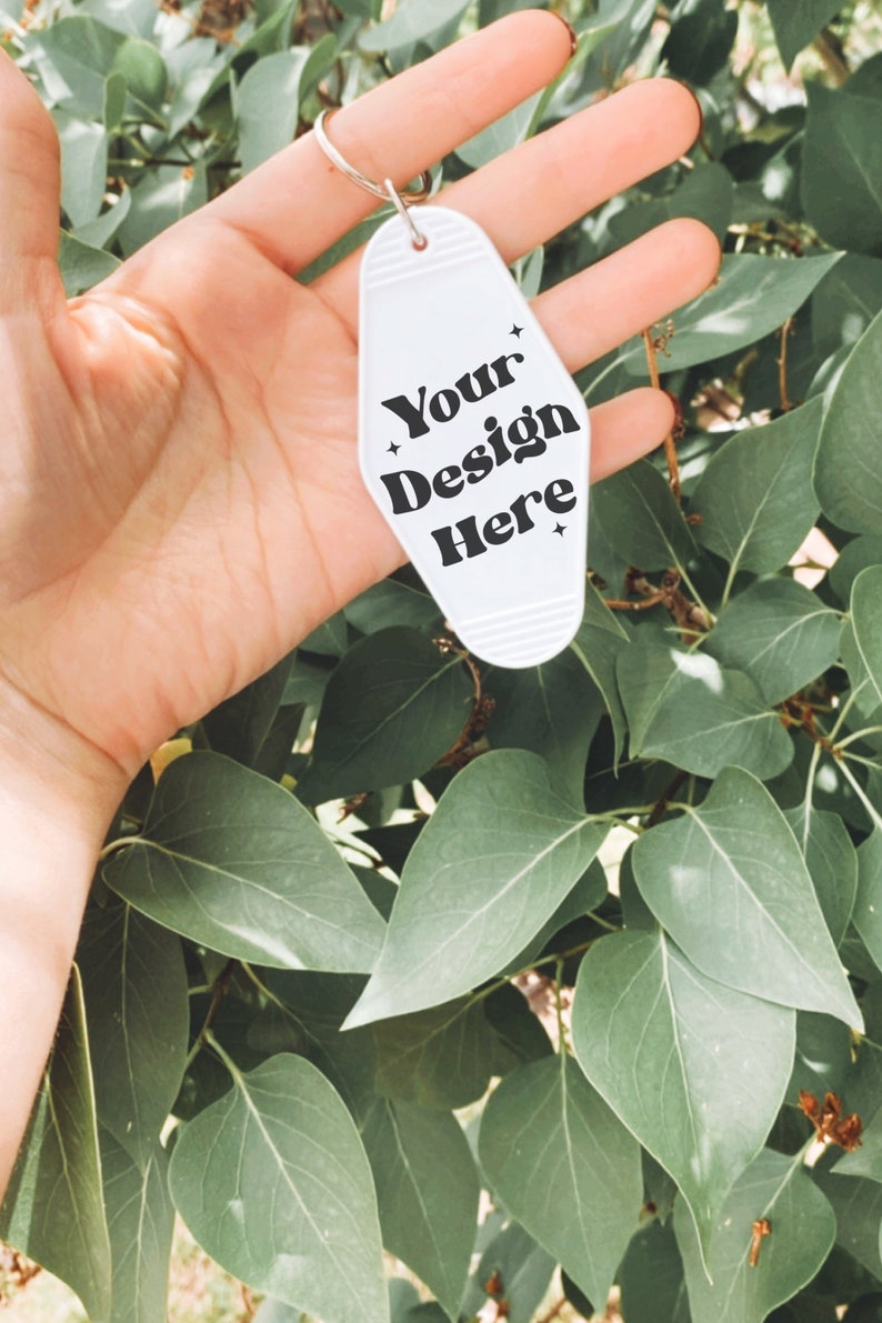 May include: White motel key chain with black text that reads "Your Design Here".