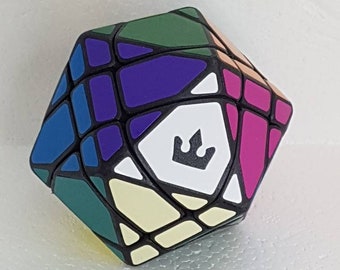 May include: A black 12-sided puzzle with a crown logo. The puzzle has a variety of colors including purple, blue, green, pink, and white.