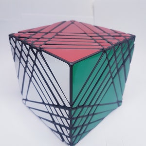 May include: A multi-colored puzzle cube with red, green, white, and black panels. The cube has a complex design with many triangular and rectangular shapes. The edges are black, and the cube is set against a white background.