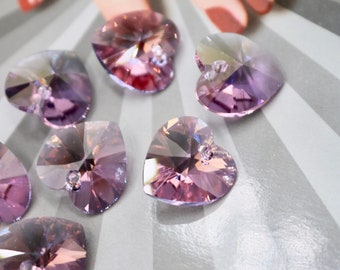May include: A group of eight heart-shaped crystal charms in shades of pink and purple. The charms have a faceted design and a hole at the top for hanging.