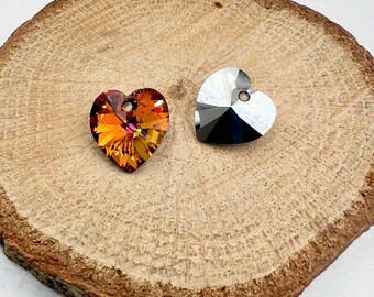 May include: Two heart-shaped crystal charms, one in a clear iridescent finish and the other in a warm amber color with red and orange hues.