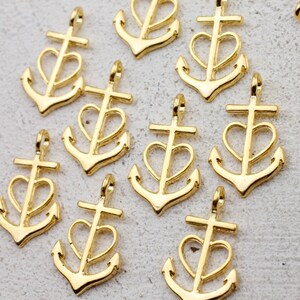 May include: A collection of gold-toned metal charms shaped like anchors with a heart design. Each charm has a loop at the top for attaching to a necklace, bracelet, or other jewelry.