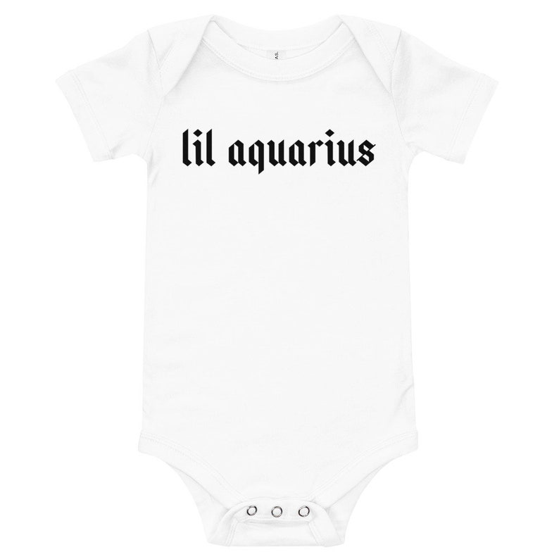 May include: White baby onesie with short sleeves and black text that reads "lil aquarius" in a gothic font.