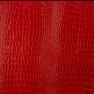 May include: Red faux crocodile skin texture. The texture is embossed with a repeating pattern of scales.