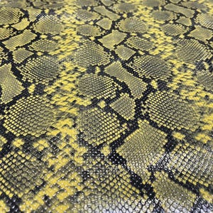 May include: Yellow and black snakeskin pattern fabric. The fabric has a glossy finish.