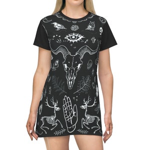 Może przedstawiać: Czarna sukienka t-shirt z białym nadrukiem r&oacute;żnych symboli okultystycznych, w tym czaszki, oka, dłoni, jelenia i ptaka.