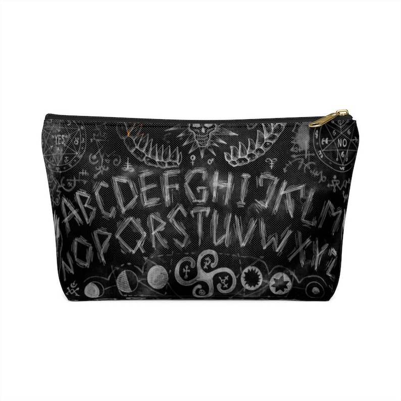 May include: Black zippered pouch with a white ouija board design. The design includes the letters of the alphabet, numbers, and the words "yes" and "no".