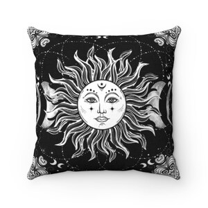 Puede incluir: Almohada de color negro y blanco con un dise&ntilde;o de sol y luna. El sol tiene una cara y la luna es una media luna. El fondo es negro con estrellas blancas.