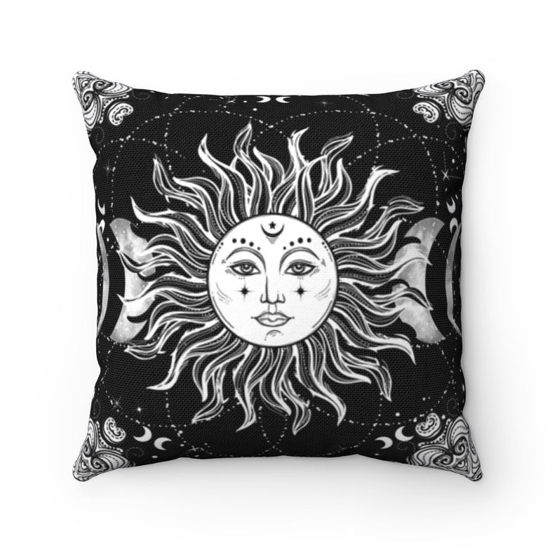 Puede incluir: Almohada de color negro y blanco con un dise&ntilde;o de sol y luna. El sol tiene una cara y la luna es una media luna. El fondo es negro con estrellas blancas.