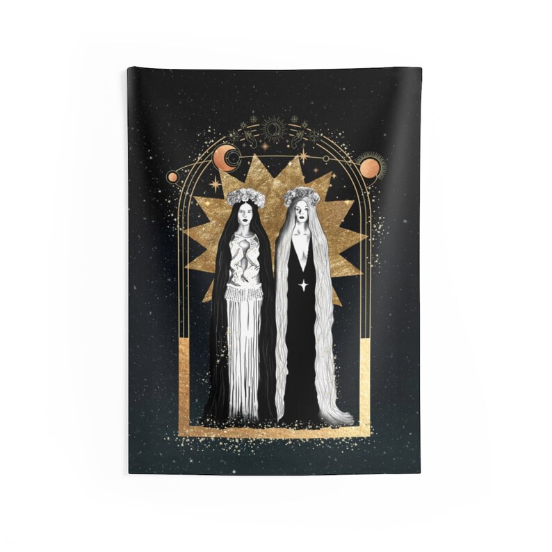 May include: Two figures in white and black gowns stand within a gold starburst frame against a black background with gold stars. The figures wear crowns and have long hair. The frame is surrounded by a gold archway with celestial symbols.