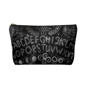 May include: Black and white makeup bag with a Ouija board design. The bag features the letters of the alphabet, numbers, and the words "yes" and "no".