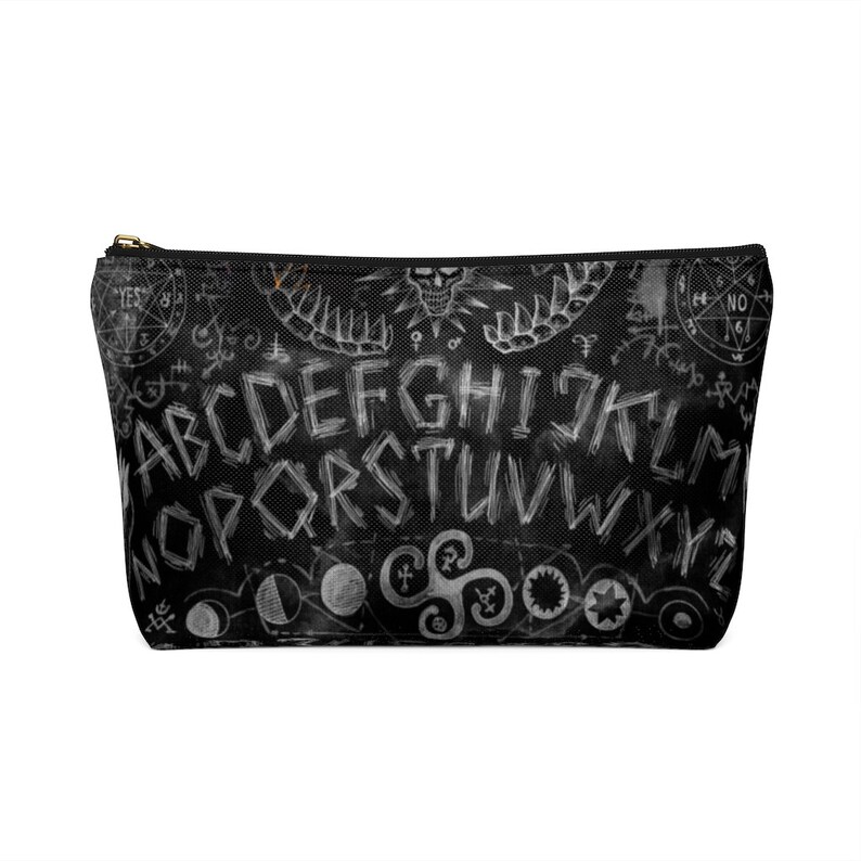 May include: Black and white makeup bag with a Ouija board design. The bag features the letters of the alphabet, numbers, and the words "yes" and "no".