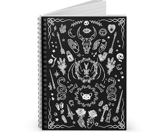 May include: Black and white spiral notebook with a cover featuring a variety of occult and witchcraft symbols, including a skull, a bat, a snake, a crescent moon, a pentagram, a key, a rose, and a cat.