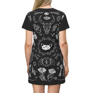 May include: Black t-shirt dress with a white print of various occult and mystical symbols, including a skull, an eye, a cat, roses, and bones.