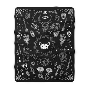 Op de afbeelding: Zwart-witte illustratie van verschillende occulte en mystieke symbolen, waaronder een kat, een slang, een schedel, kristallen, tarotkaarten en een halve maan. De symbolen zijn in een cirkelvormige opstelling op een zwarte achtergrond geplaatst.