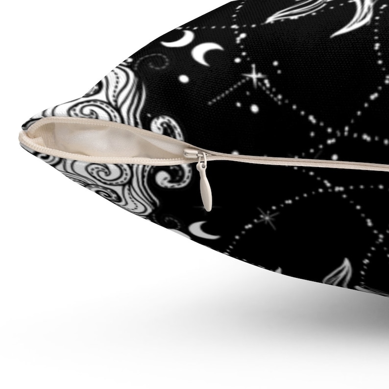 Puede incluir: Una almohada de tiro de color negro y blanco con cierre de cremallera. La almohada presenta un patr&oacute;n repetitivo de lunas, estrellas y remolinos.