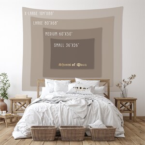 May include: A tapestry with the text "Shores of Moon" in gold lettering. The tapestry is displayed on a wall with a white background. The tapestry is available in four sizes: X-Large (104 inches by 88 inches), Large (80 inches by 68 inches), Medium (60 inches by 50 inches), and Small (36 inches by 26 inches).