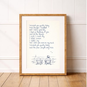 May include: A wooden framed print with handwritten blue ink text. The text reads, "I missed you quietly today...and the pain stays only mine." A sketch of two chairs overlooking the sea is below the text. The frame is made of wood.